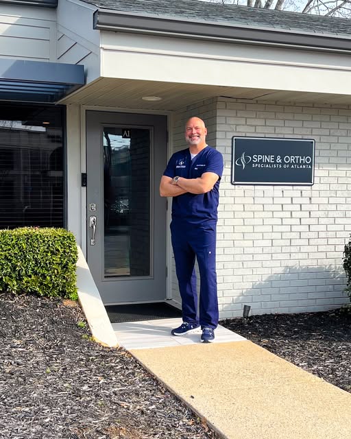Dr. Brad Prybis wearing navy scrubs outside the practice